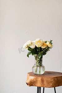 玫瑰花粥摄影照片_简约的家居内饰，配有时尚的木制咖啡桌和一束新鲜玫瑰