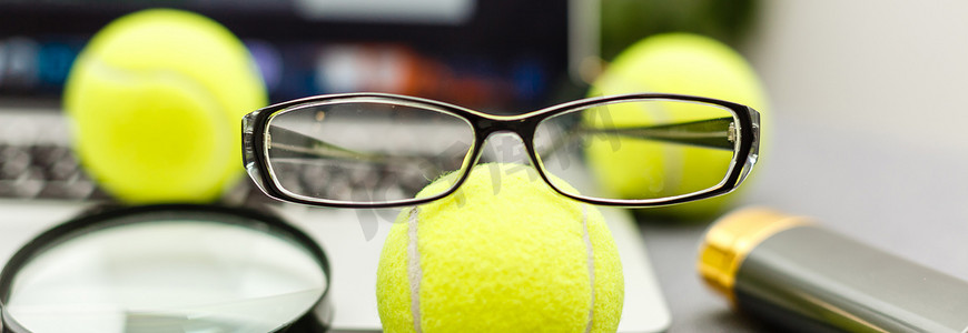 笔记本电脑、运动器材、网球、体育管理白桌上的眼镜的顶视图。商业理念。