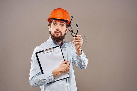 一个身着橙色油漆、手里拿着文件的男人正在建立一家工业企业