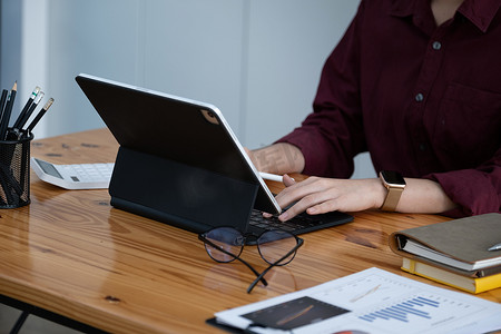 一名公司女员工正在使用平板电脑上网查找信息。