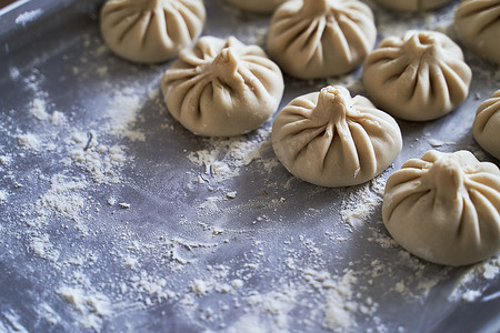 家庭餐桌上堆着一堆自制的生 khinkali 美味格鲁吉亚饺子