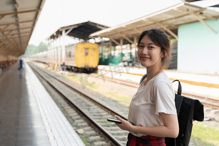 肖像年轻的亚洲女性背包客在火车站旅行。