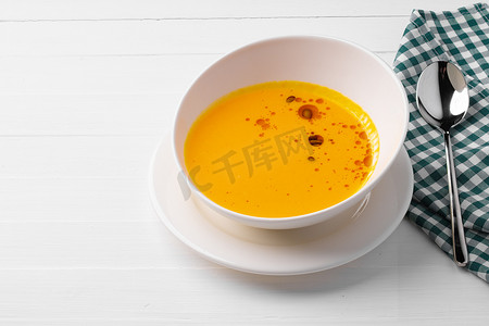 南瓜奶油汤在白色木质背景的碗中供应