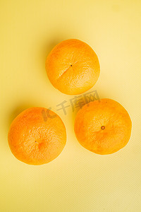 明亮的成熟橘子，在黄色质感的夏季背景中，顶视图平躺