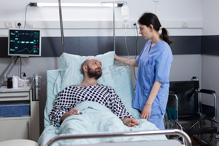 护士固定枕头照顾与生命体征监测仪相连的呼吸功能不全患者
