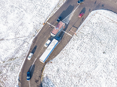 物流园区的鸟瞰图，包括仓库、装卸中心和许多半卡车，货物拖车站在斜坡上装卸货物 a