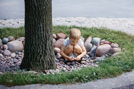 小男孩在公园里捡石头。