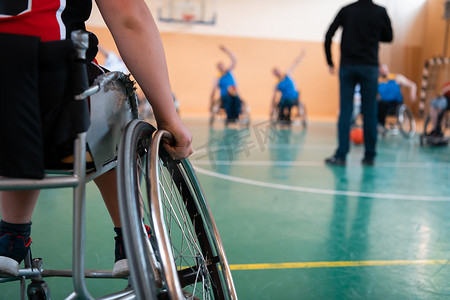 残疾人运动摄影照片_残疾篮球队的选拔员站在球员面前，为他们展示训练开始前的伸展运动