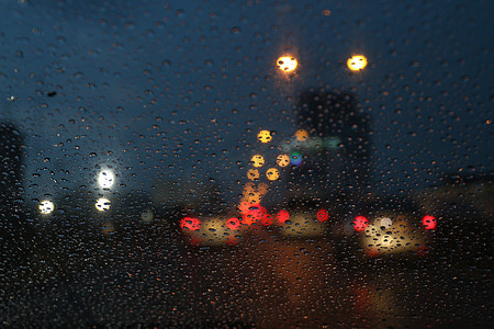 夜生活背景散景和玻璃上的雨滴模糊散景照明彩色凝结