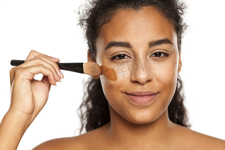 一位年轻的黑皮肤女性使用液体化妆包的肖像