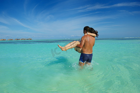 亚洲比基尼摄影照片_亚洲夫妇在海滩上享受夏天