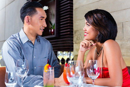 高档眼镜摄影照片_亚洲夫妇在高档酒吧喝鸡尾酒