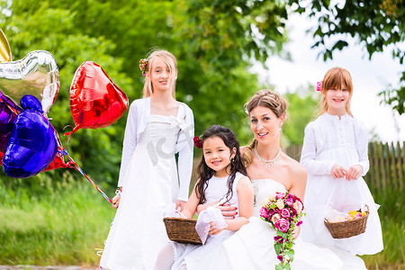 新娘与女孩作为伴娘、鲜花和气球