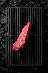 黑铸铁烤架上的一块瘦猪里脊肉放在冷煤上