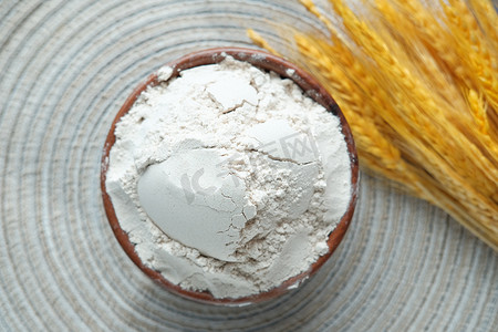 碗里的小麦粉和桌子上的麦穗