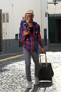 全身快乐的非洲裔美国旅行人背着包和手机走在街上