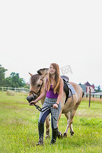 美女下载摄影照片_牧场里与马站在一起的年轻美女肖像