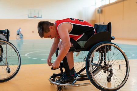男孩坐在轮椅上，为大竞技场的篮球比赛做准备