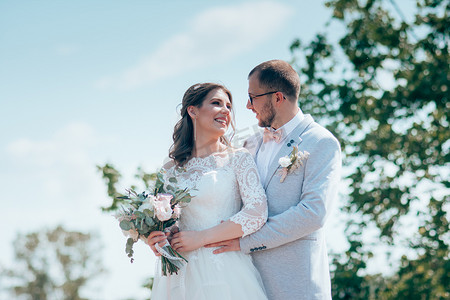 婚礼照片摄影照片_新娘和新郎在森林和岩石的大自然中以灰粉色的婚礼照片。