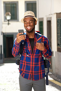 背包的行人摄影照片_带着背包和手机的微笑旅行人