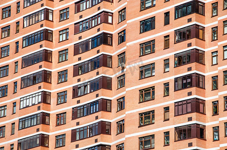 带窗户的砖墙摄影照片_带窗户和阳台的砖墙红色现代公寓楼景观