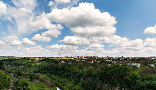 卡梅内茨波多多云天空下的河流峡谷和房屋