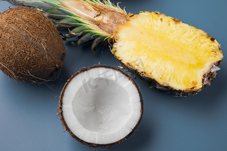 平铺菠萝摄影照片_新鲜水果、菠萝和椰子，在蓝色质感的夏季背景中，俯视平躺
