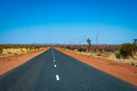 卡里姆摄影照片_穿过红沙澳大利亚景观通往卡里吉尼国家公园的黑暗道路旁的沙尘暴