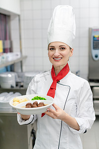 美食广告餐饮摄影照片_食堂商业厨房厨师展示盘子里的食物