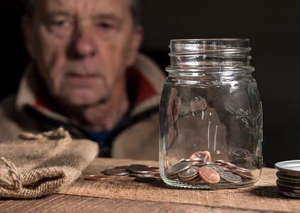 贫困老人摄影照片_白人退休老人看着剩余的积蓄