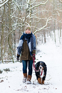 冬天带着狗远足或散步的妇女