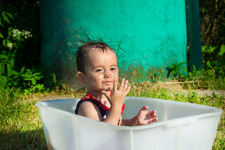 大热天坐在浴缸里微笑的小女孩