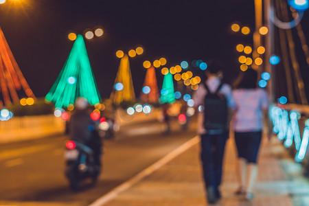 背景中的年轻夫妇夜间在一座桥上繁忙的交通。