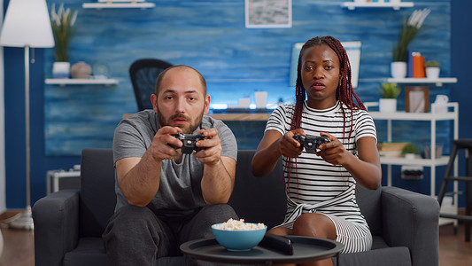 现代跨种族夫妇在电视上玩电子游戏