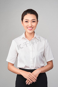 正式摄影照片_灰色背景的正式亚裔女商人