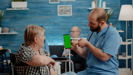 护士垂直拿着有绿色屏幕的智能手机