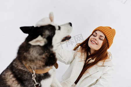 雪地里的女人和狗玩耍有趣的友谊新鲜空气