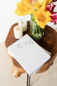 时尚木制咖啡桌上的白皮书空白封面模型，上面放着郁金香花束，高视角