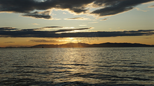 海上美丽的橙色日落，远处的岛屿