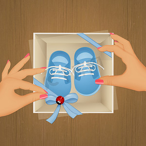 鞋子男孩摄影照片_礼品盒中的蓝色婴儿鞋