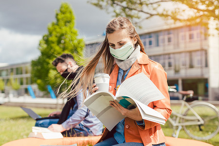 校园安全摄影照片_戴口罩在大学校园学习的女学生