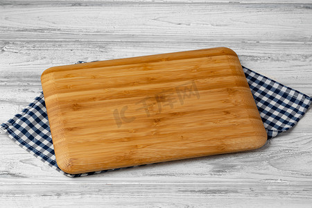 切菜板摄影照片_木桌上有棉餐巾的切菜板