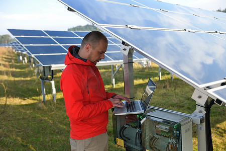 工程师在太阳能电池板厂区使用笔记本电脑
