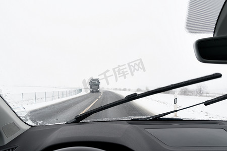 白色汽车背景摄影照片_从汽车到有雪的道路