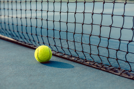 网球场网前荧光黄球的特写