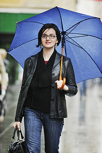下雨打伞摄影照片_街上打伞的女人