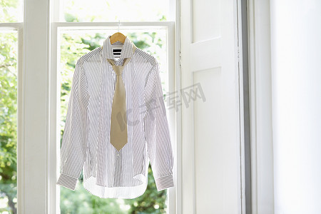 国内窗户衣架上的礼服衬衫和领带