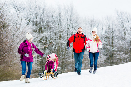有孩子的家庭在雪地里冬天散步