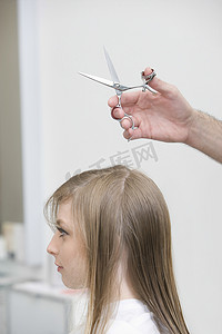 男人在理发店给年轻女人剪头发