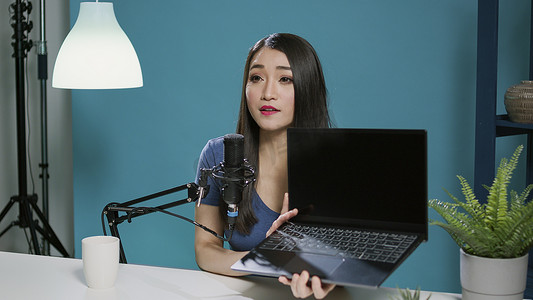 亚洲女性在社交媒体播客上查看笔记本电脑